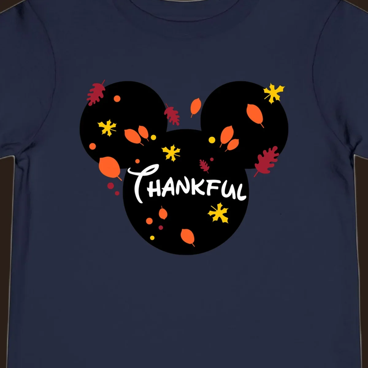 Mickey ears shape with fall leaves and the word THANKFUL in white text.