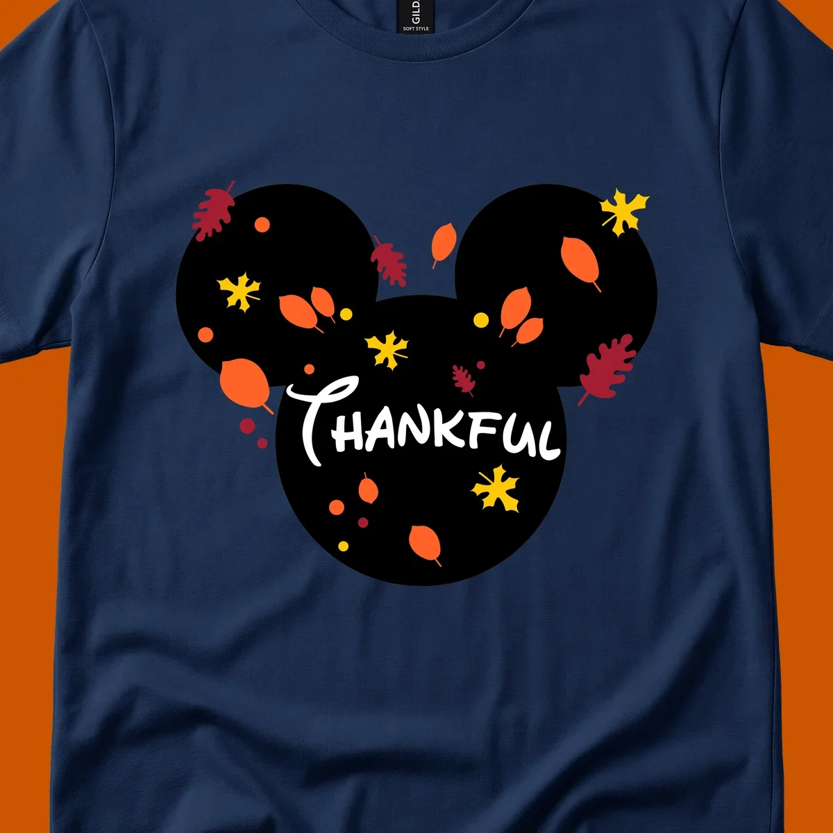 Mickey ears shape with fall leaves and the word THANKFUL in white text.