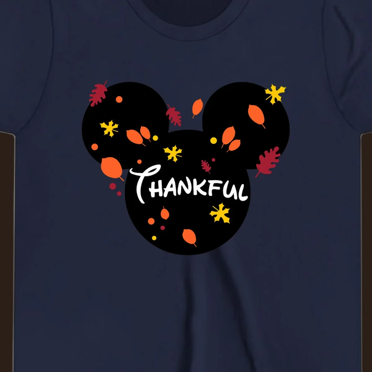Mickey ears shape with fall leaves and the word THANKFUL in white text.