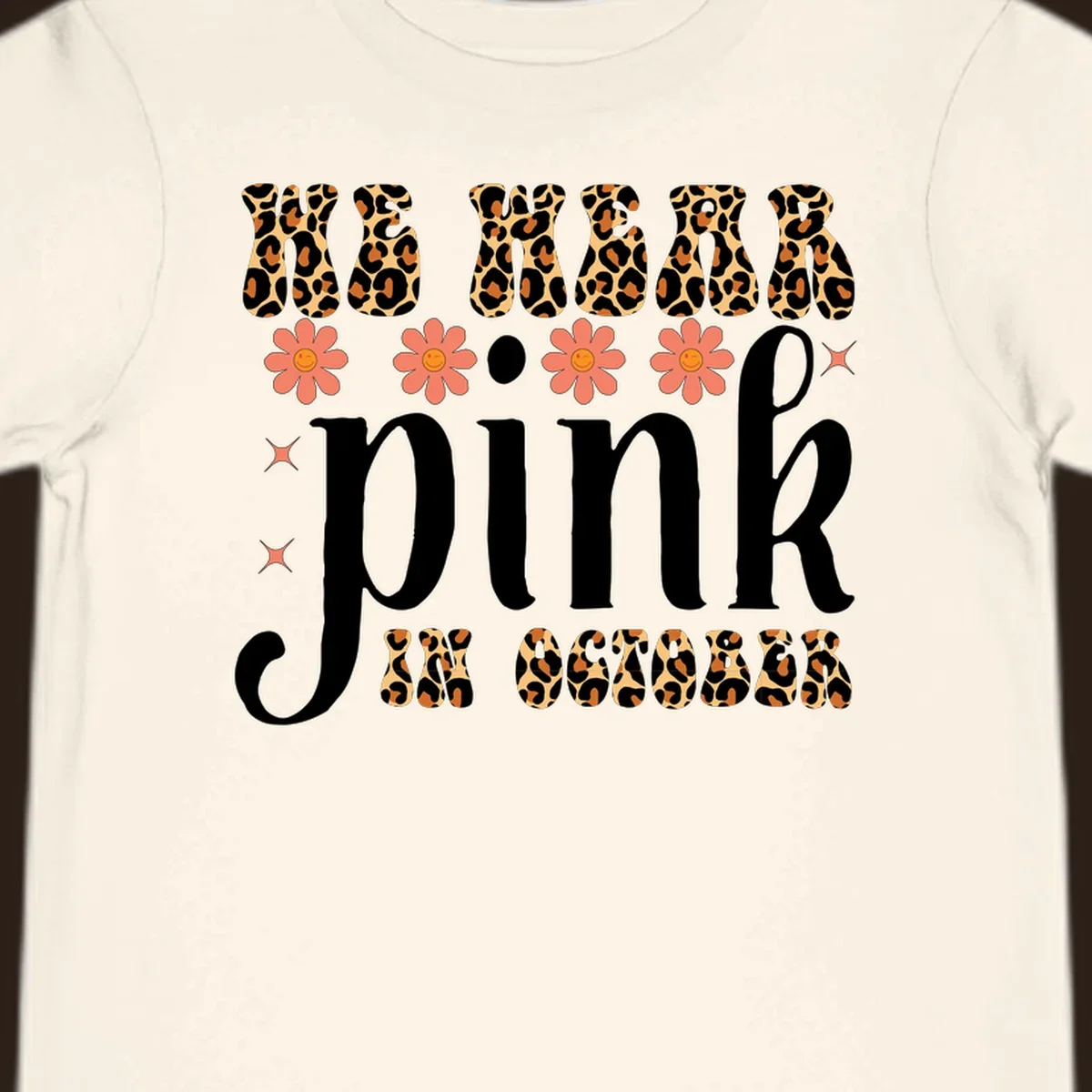 Retro "WE WEAR pink IN OCTOBER" design with leopard print and smiling flowers.