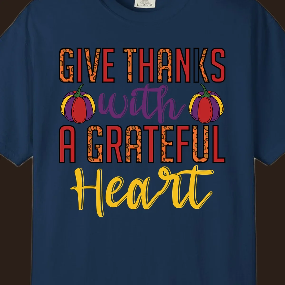 Give Thanks With A Heart typography and pumpkin design.