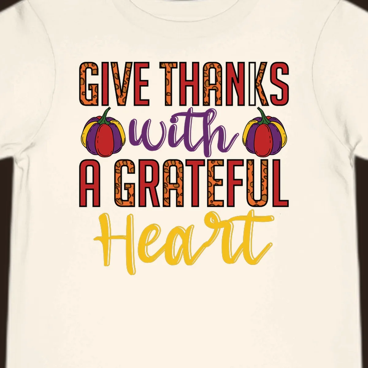 Give Thanks With A Heart typography and pumpkin design.