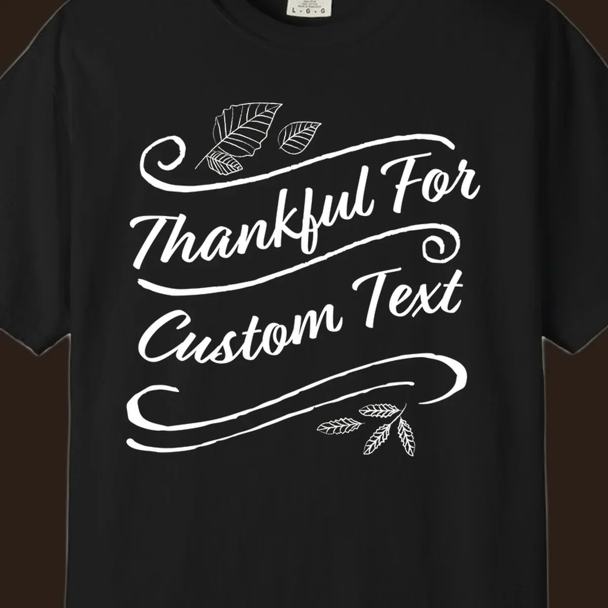 Custom Thanksgiving text design with leaves and swirls.