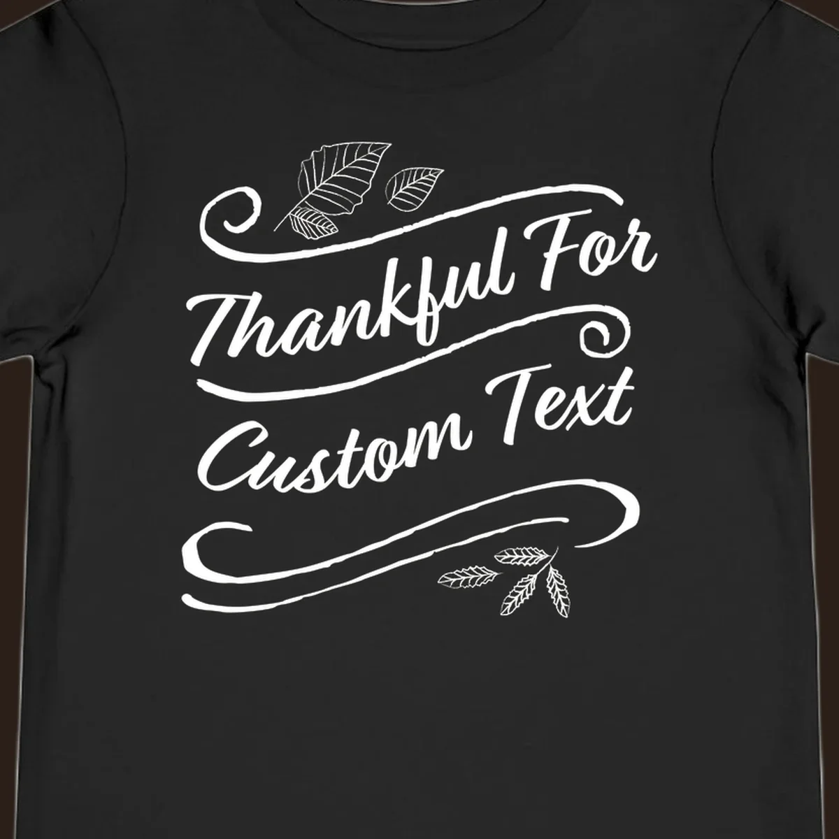 Custom Thanksgiving text design with leaves and swirls.
