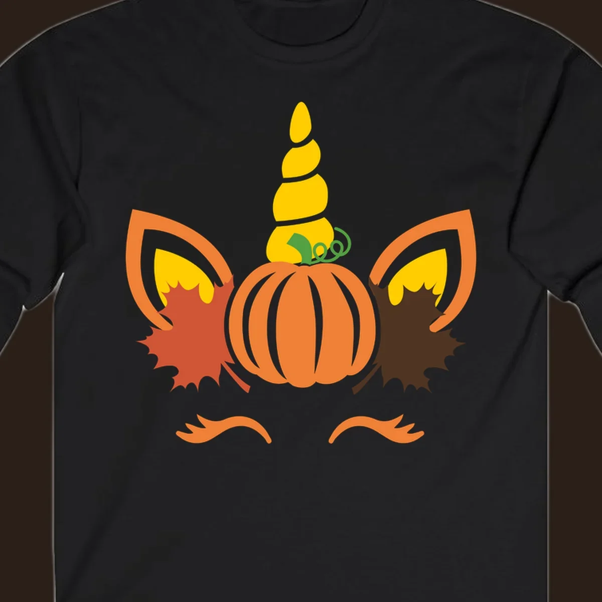 Autumn unicorn pumpkin face with fall leaves graphic.