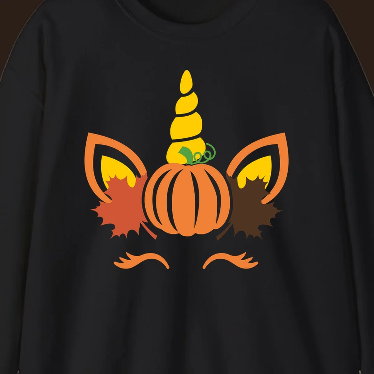 Autumn unicorn pumpkin face with fall leaves graphic.