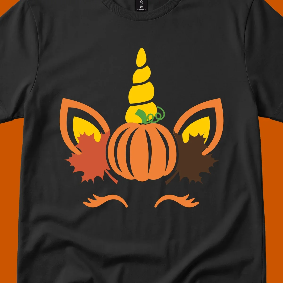 Autumn unicorn pumpkin face with fall leaves graphic.
