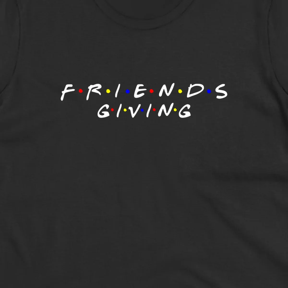 Friendsgiving typography design in white with red, yellow, and blue dots.