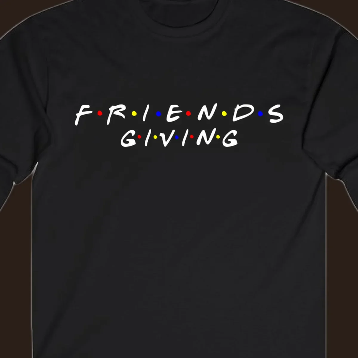 Friendsgiving typography design in white with red, yellow, and blue dots.