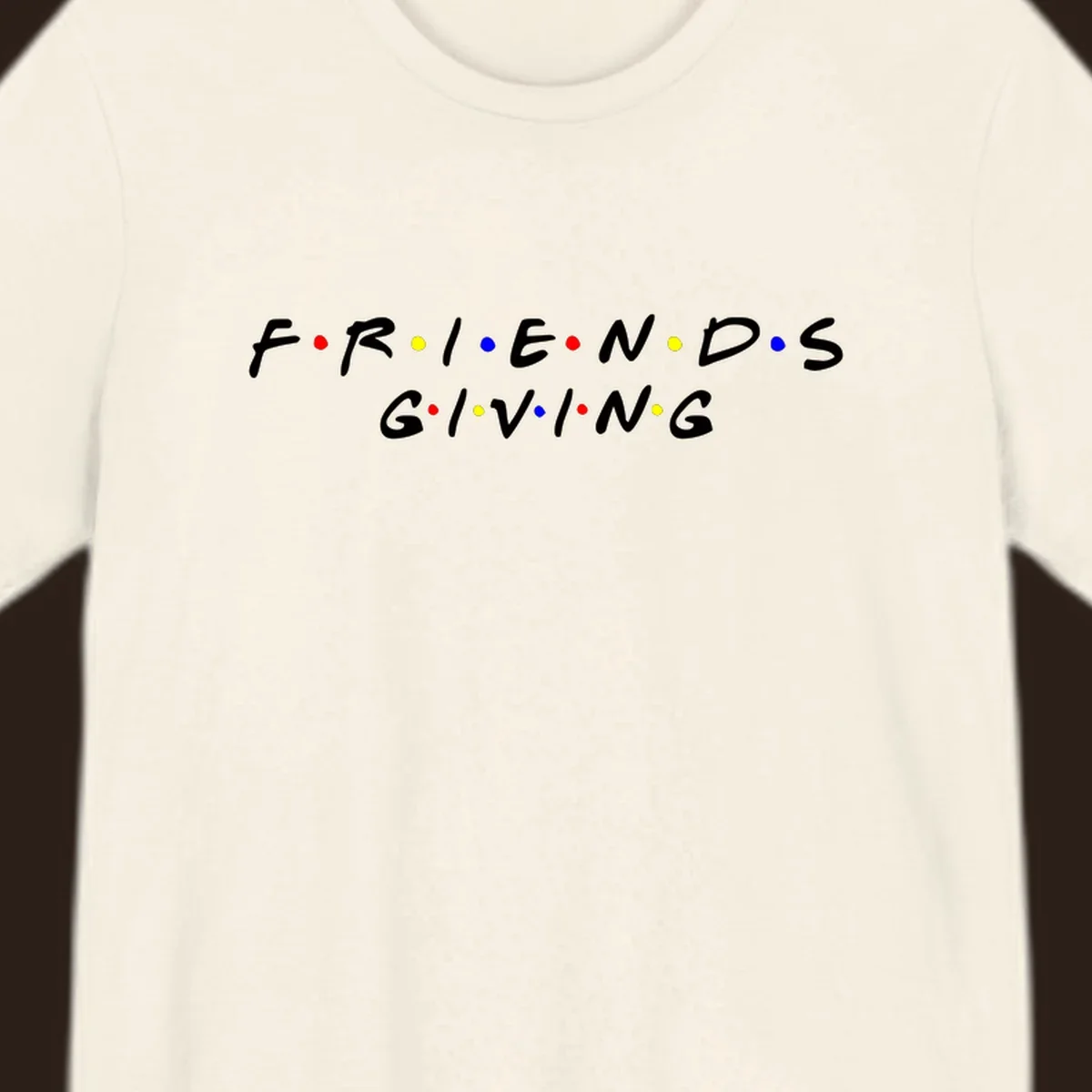 Friendsgiving typography design in white with red, yellow, and blue dots.