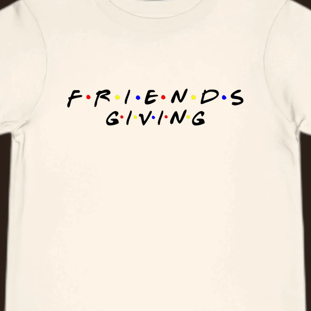 Friendsgiving typography design in white with red, yellow, and blue dots.