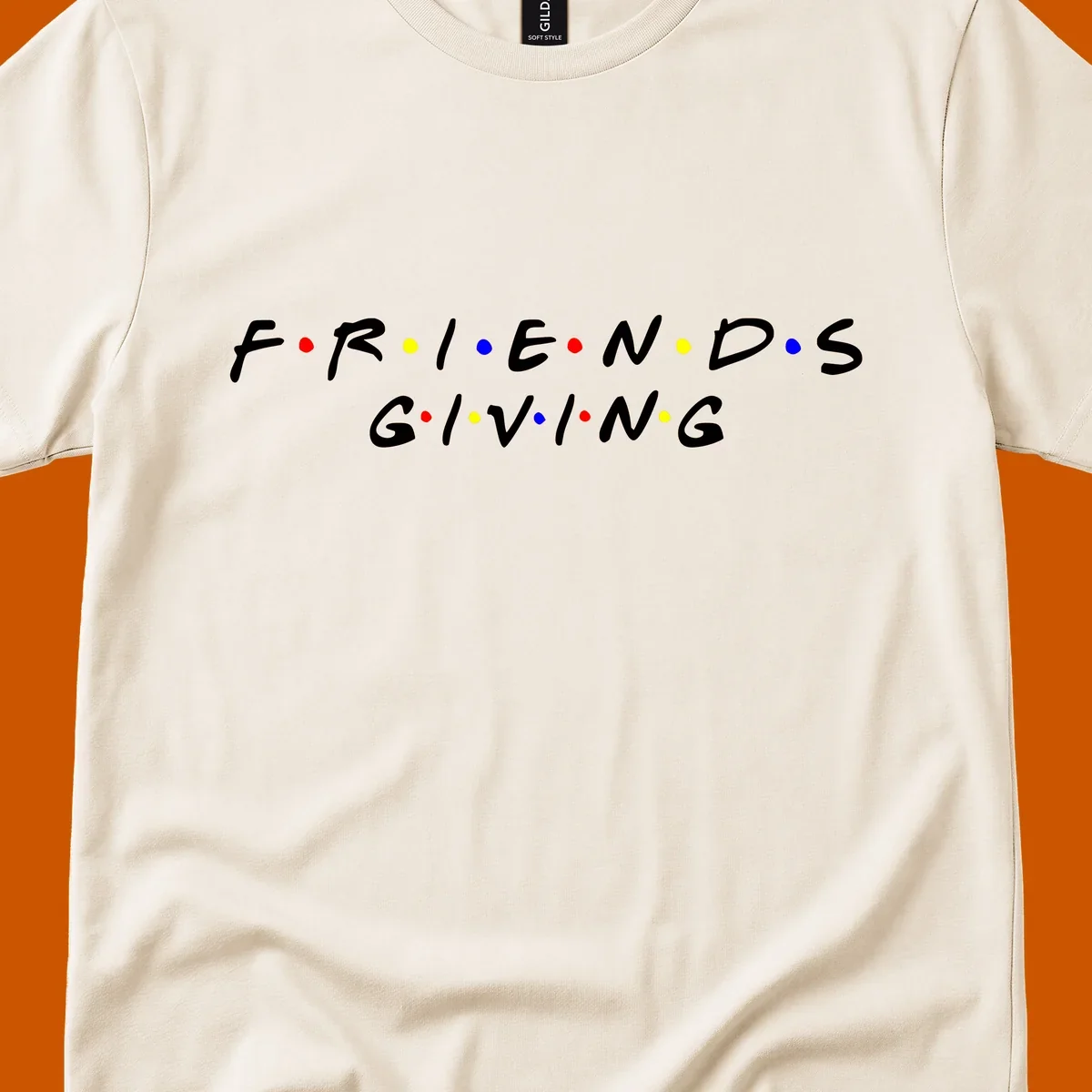 Friendsgiving typography design in white with red, yellow, and blue dots.