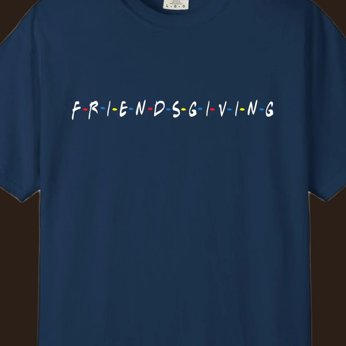 Friendsgiving typography design with white letters and colored dots on a black background.