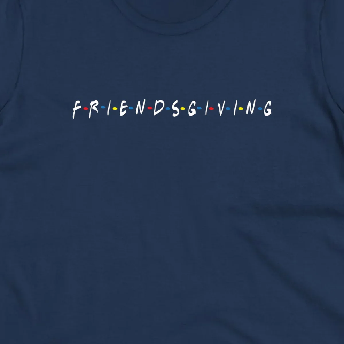 Friendsgiving typography design with white letters and colored dots on a black background.