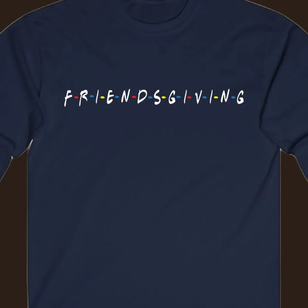 Friendsgiving typography design with white letters and colored dots on a black background.