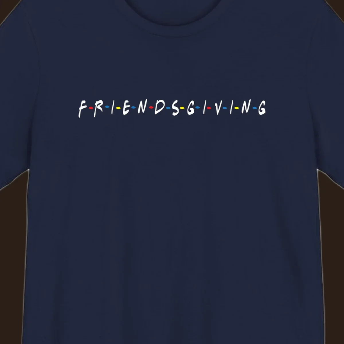 Friendsgiving typography design with white letters and colored dots on a black background.