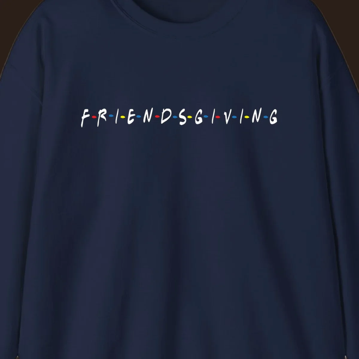 Friendsgiving typography design with white letters and colored dots on a black background.