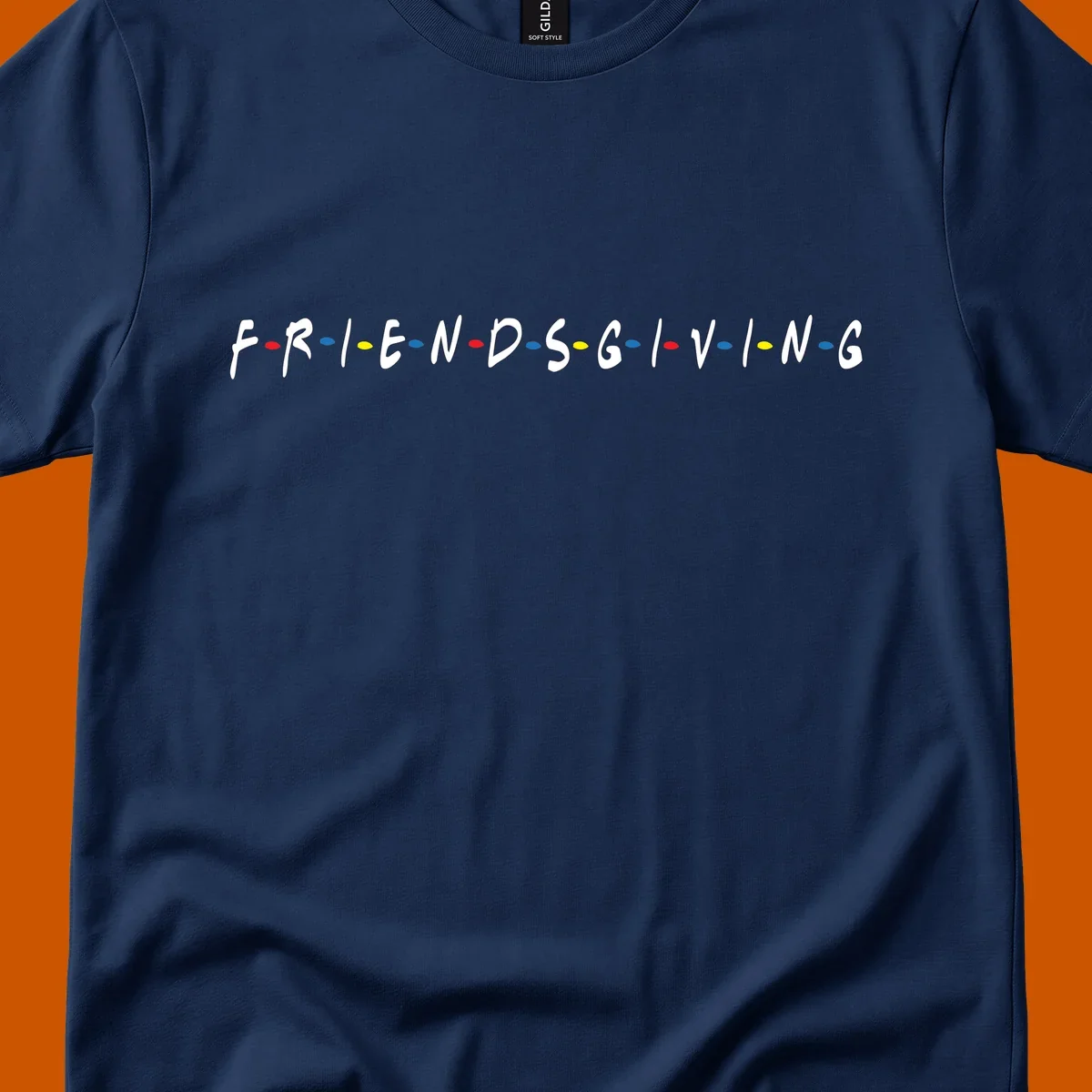 Friendsgiving typography design with white letters and colored dots on a black background.