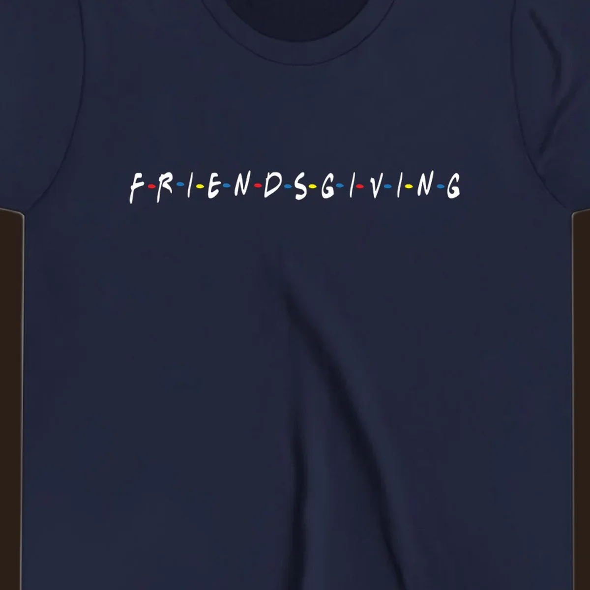Friendsgiving typography design with white letters and colored dots on a black background.