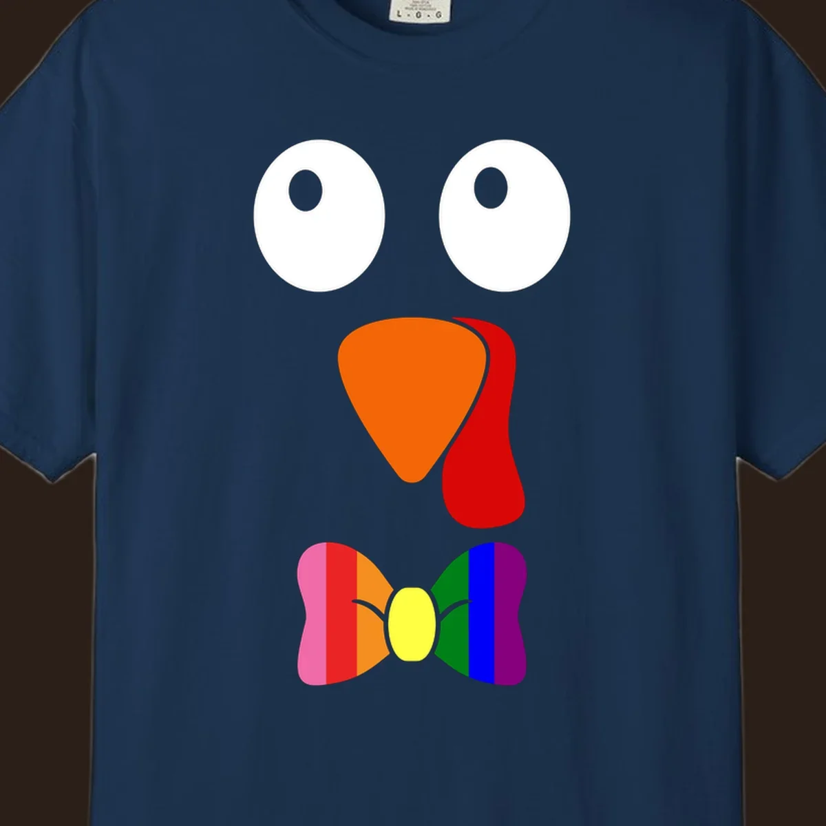 Cartoon turkey face with rainbow bowtie, featuring large eyes, orange beak, and red wattle. Thanksgiving holiday graphic.