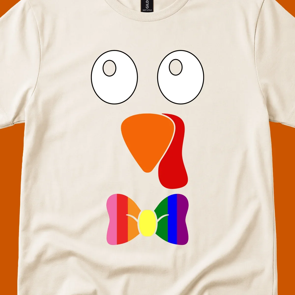 Cartoon turkey face with rainbow bowtie, featuring large eyes, orange beak, and red wattle. Thanksgiving holiday graphic.
