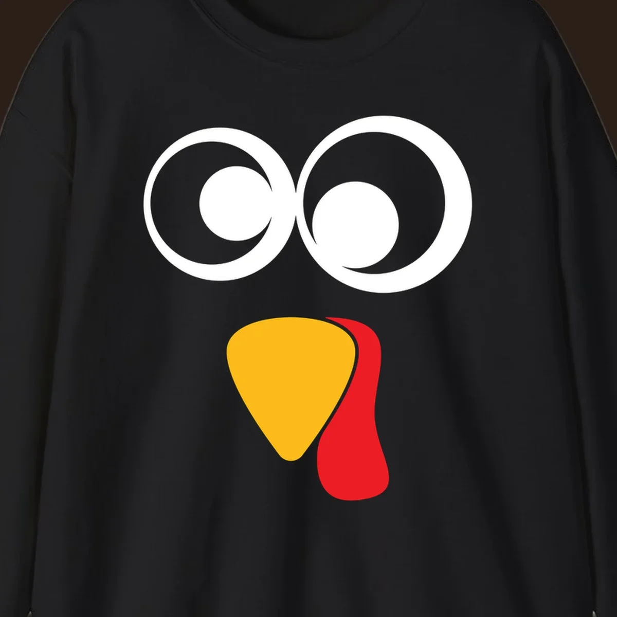 Googly-eyed turkey face illustration with yellow beak and red wattle.