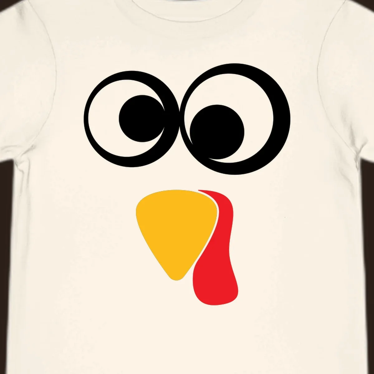 Googly-eyed turkey face illustration with yellow beak and red wattle.