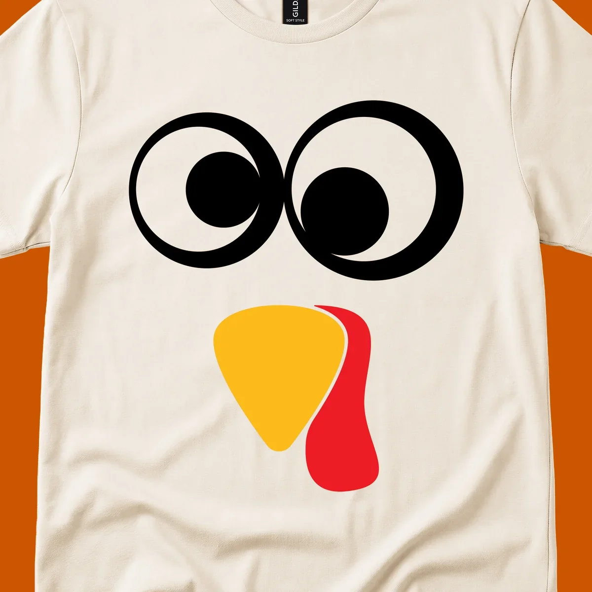 Googly-eyed turkey face illustration with yellow beak and red wattle.