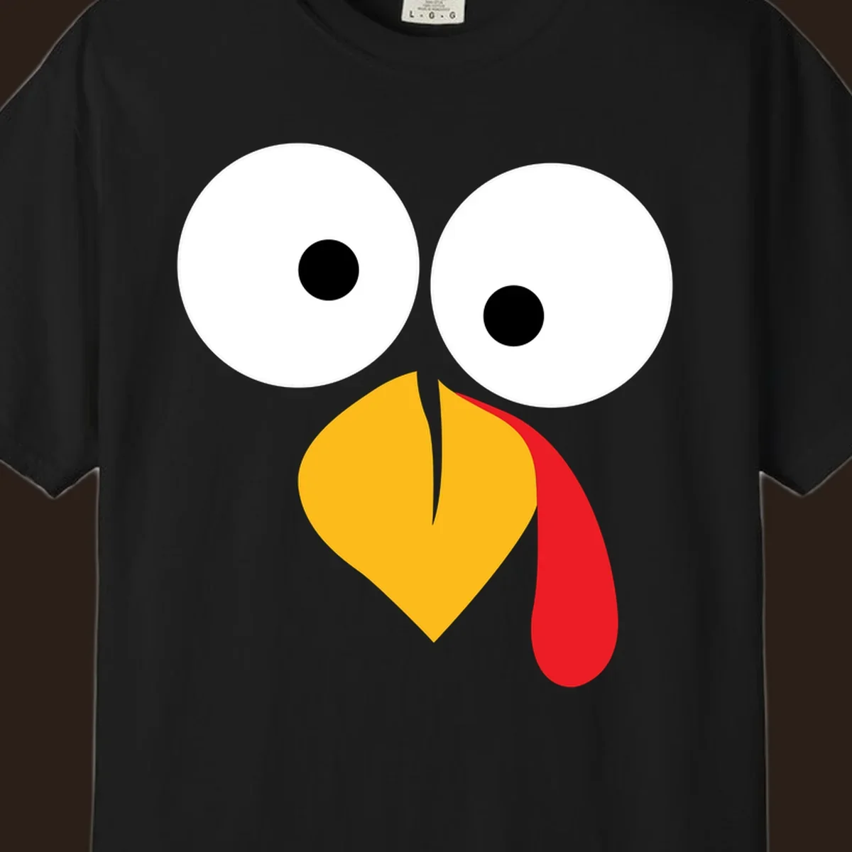 Googly-eyed turkey face illustration with yellow beak and red wattle.