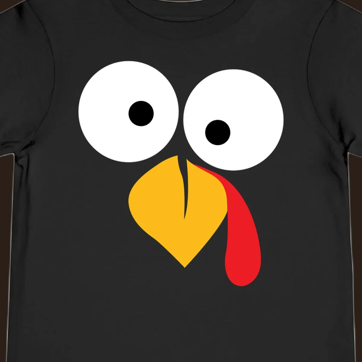 Googly-eyed turkey face illustration with yellow beak and red wattle.