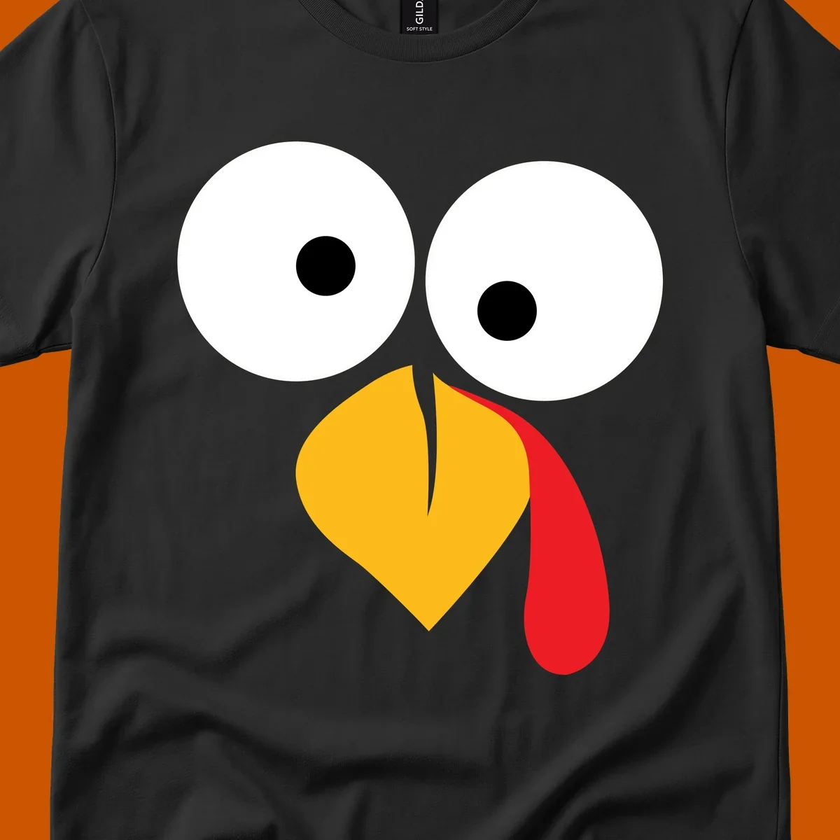 Googly-eyed turkey face illustration with yellow beak and red wattle.