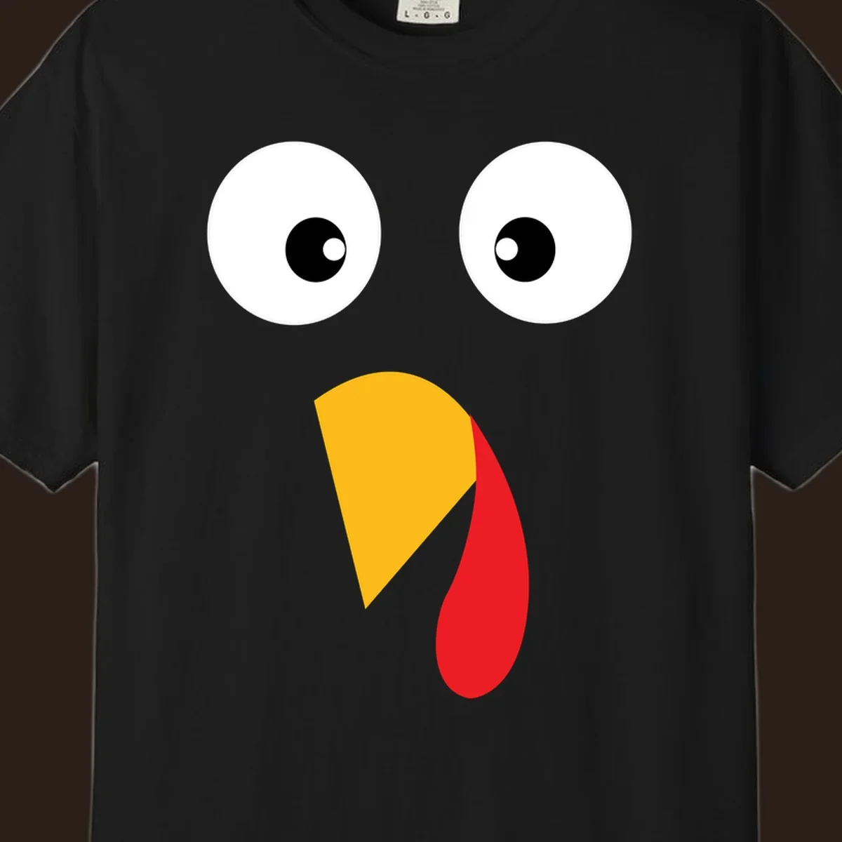 Googly eyed turkey face illustration with yellow beak and red wattle on black background.