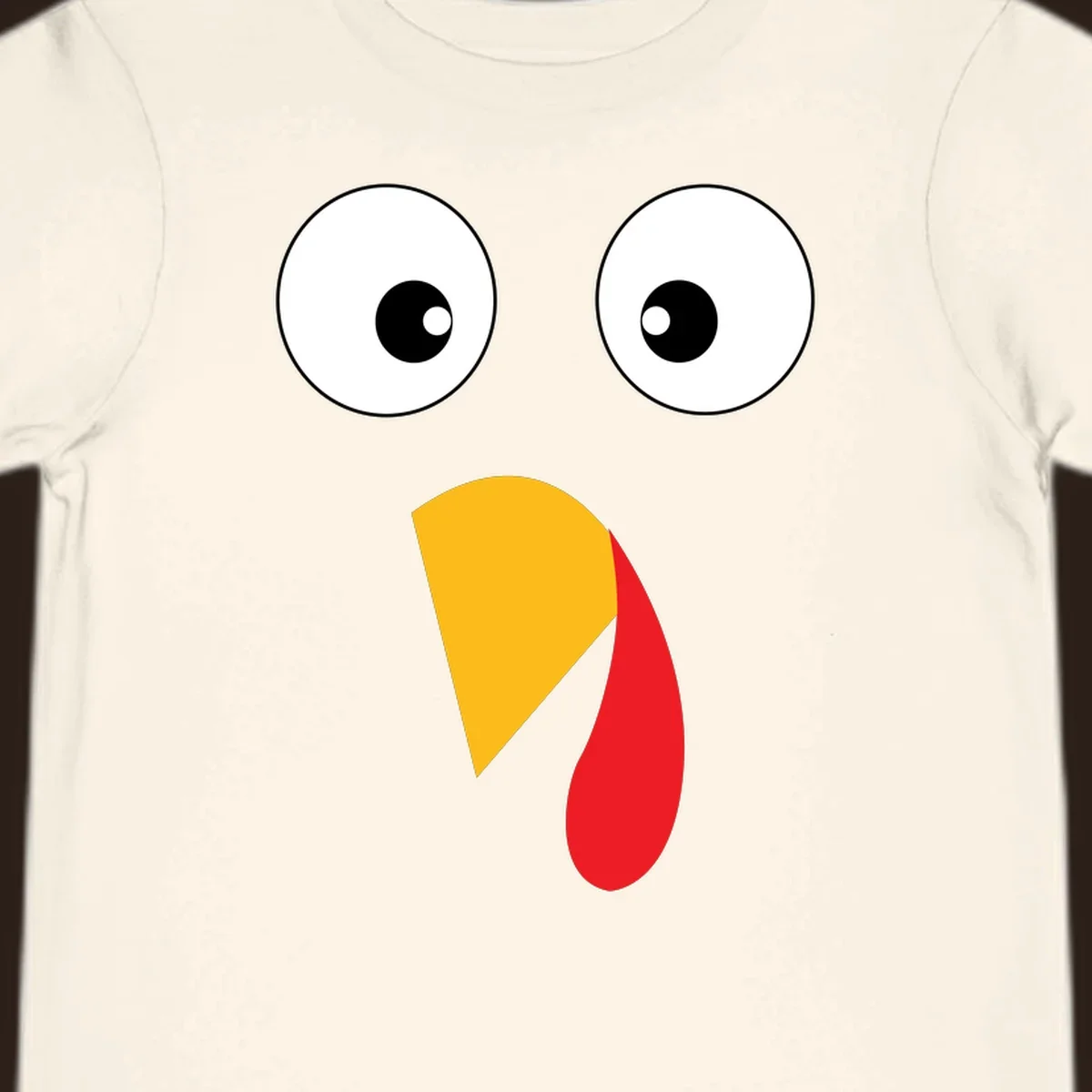Googly eyed turkey face illustration with yellow beak and red wattle on black background.
