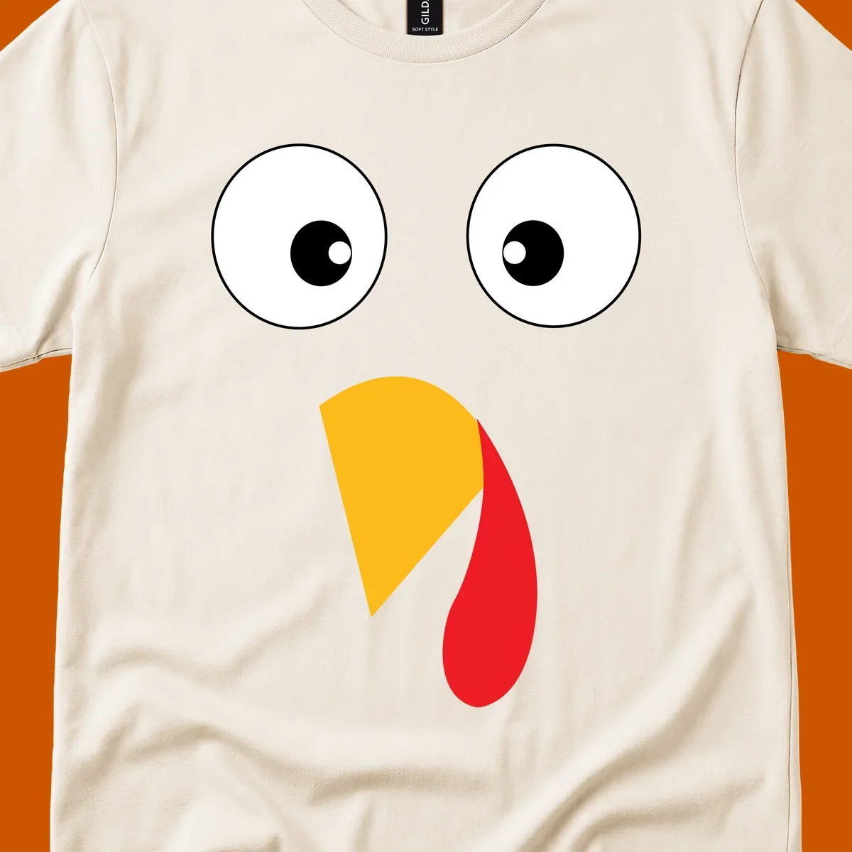 Googly eyed turkey face illustration with yellow beak and red wattle on black background.