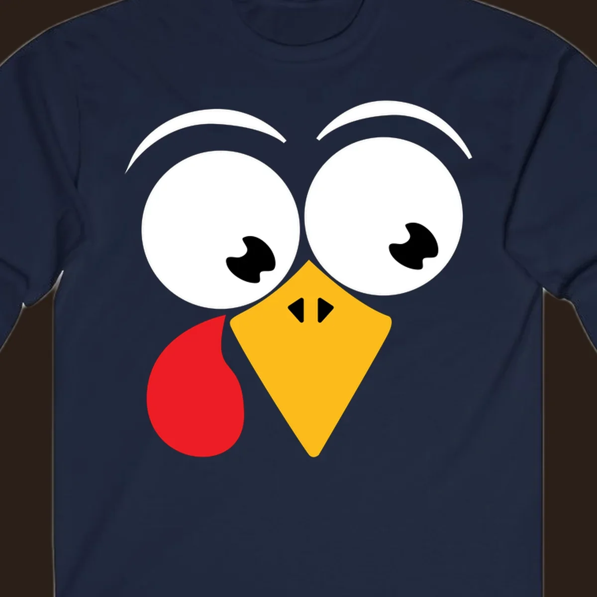 Googly eyed turkey face with yellow beak and red wattle on black background.