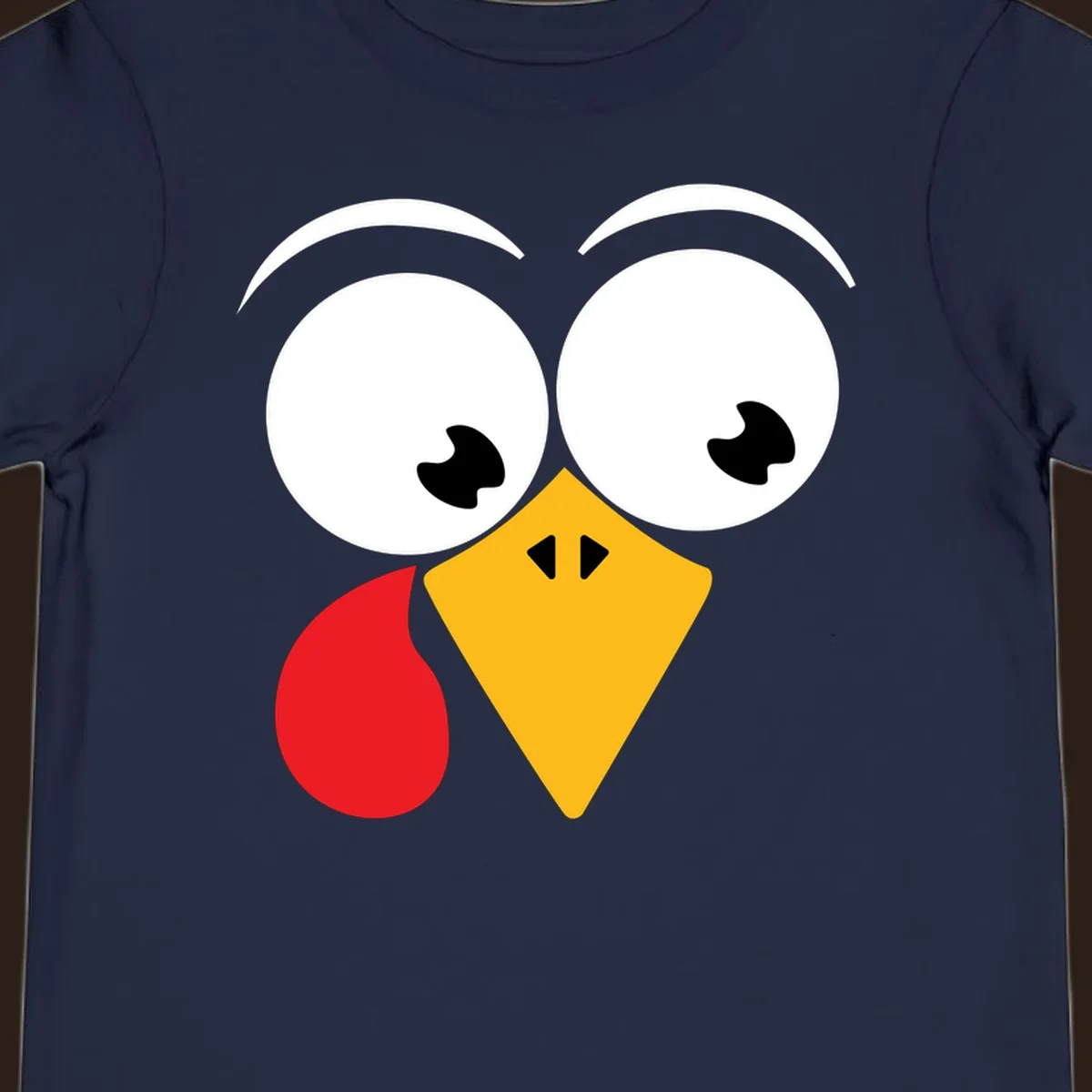 Googly eyed turkey face with yellow beak and red wattle on black background.