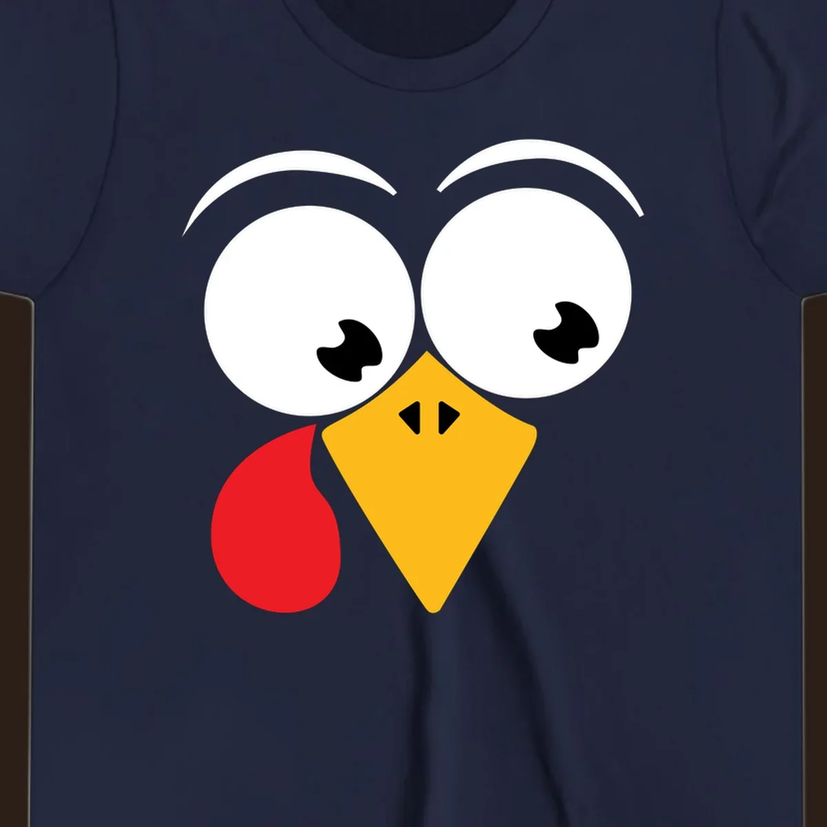 Googly eyed turkey face with yellow beak and red wattle on black background.