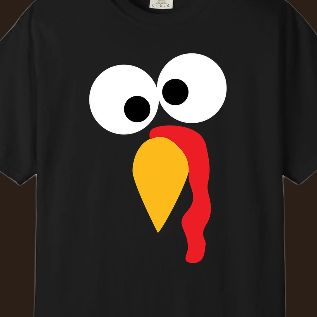 Googly-eyed turkey face illustration with yellow beak and red wattle.