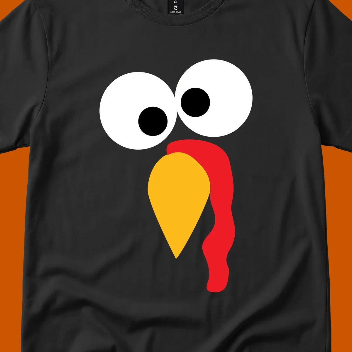Googly-eyed turkey face illustration with yellow beak and red wattle.