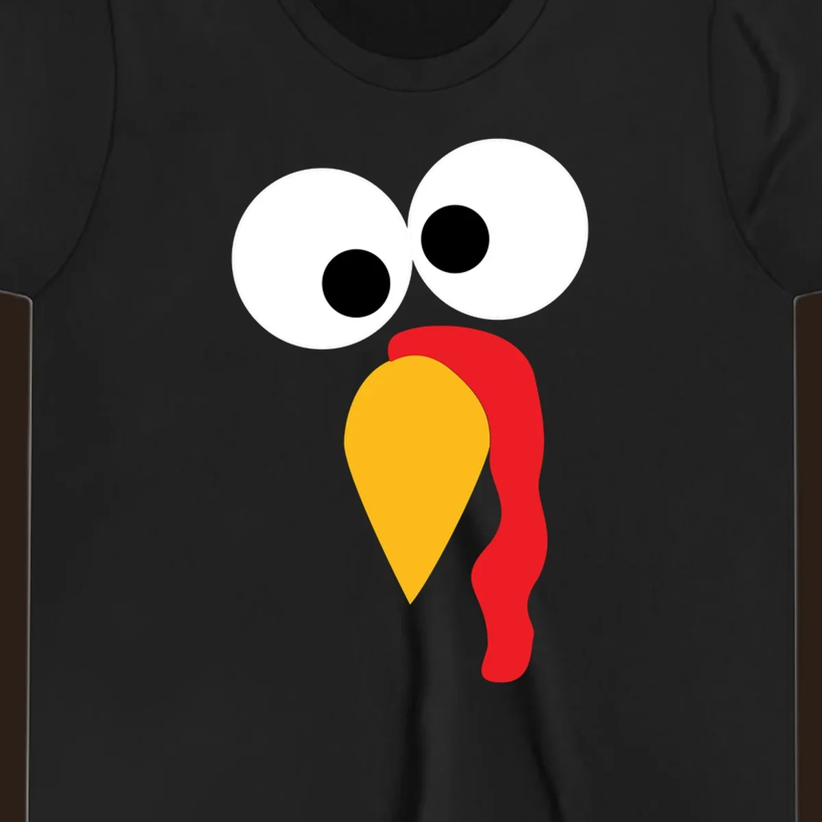 Googly-eyed turkey face illustration with yellow beak and red wattle.