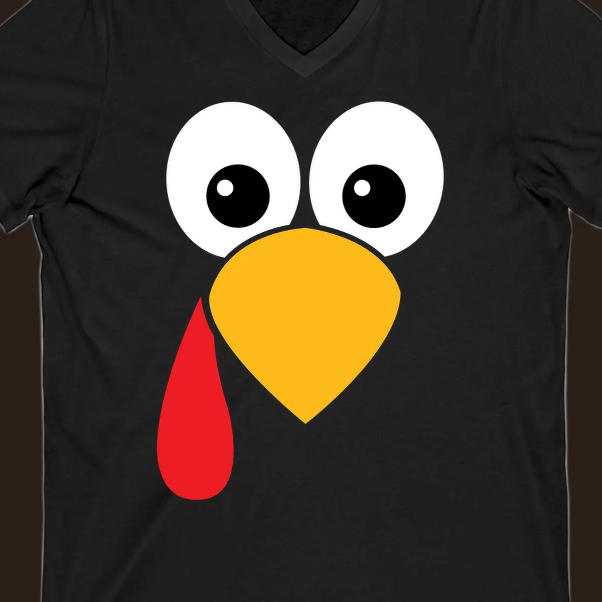 Funny turkey face illustration with big eyes, yellow beak, and red wattle for Thanksgiving.