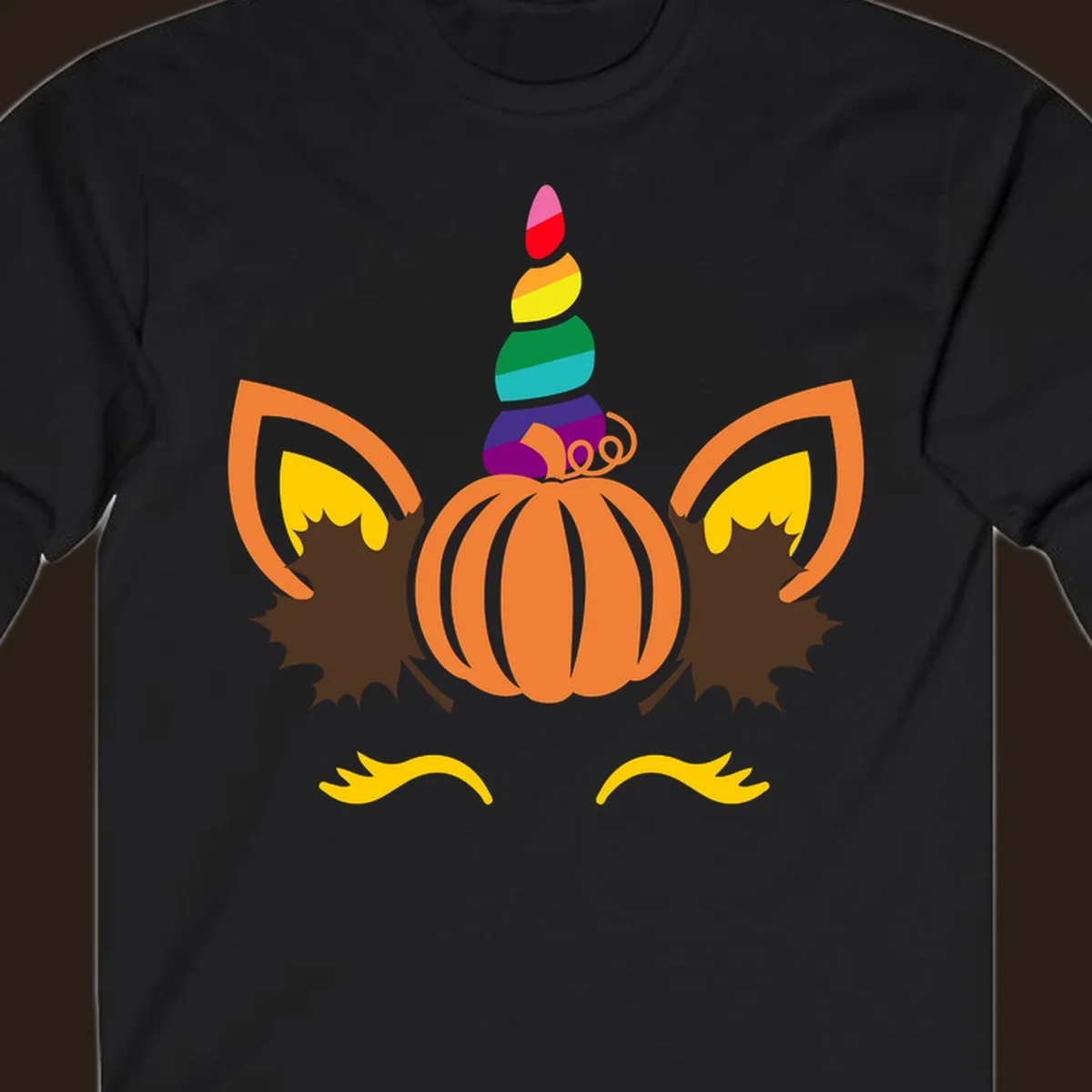 Illustration of a unicorn face made from a pumpkin with a rainbow horn and autumn leaves, on a black background.