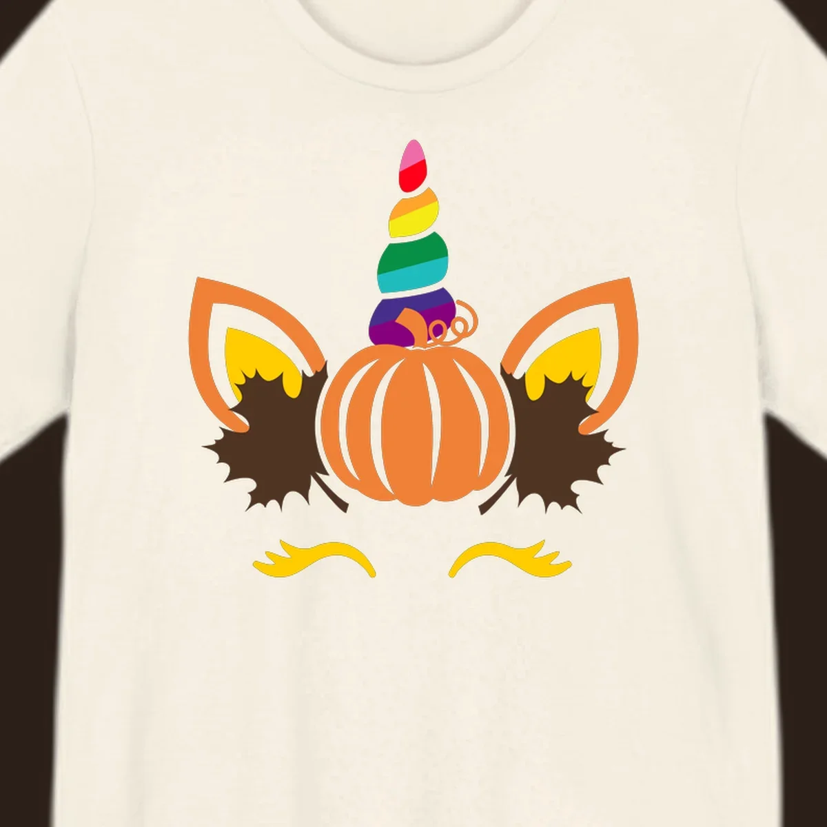 Illustration of a unicorn face made from a pumpkin with a rainbow horn and autumn leaves, on a black background.