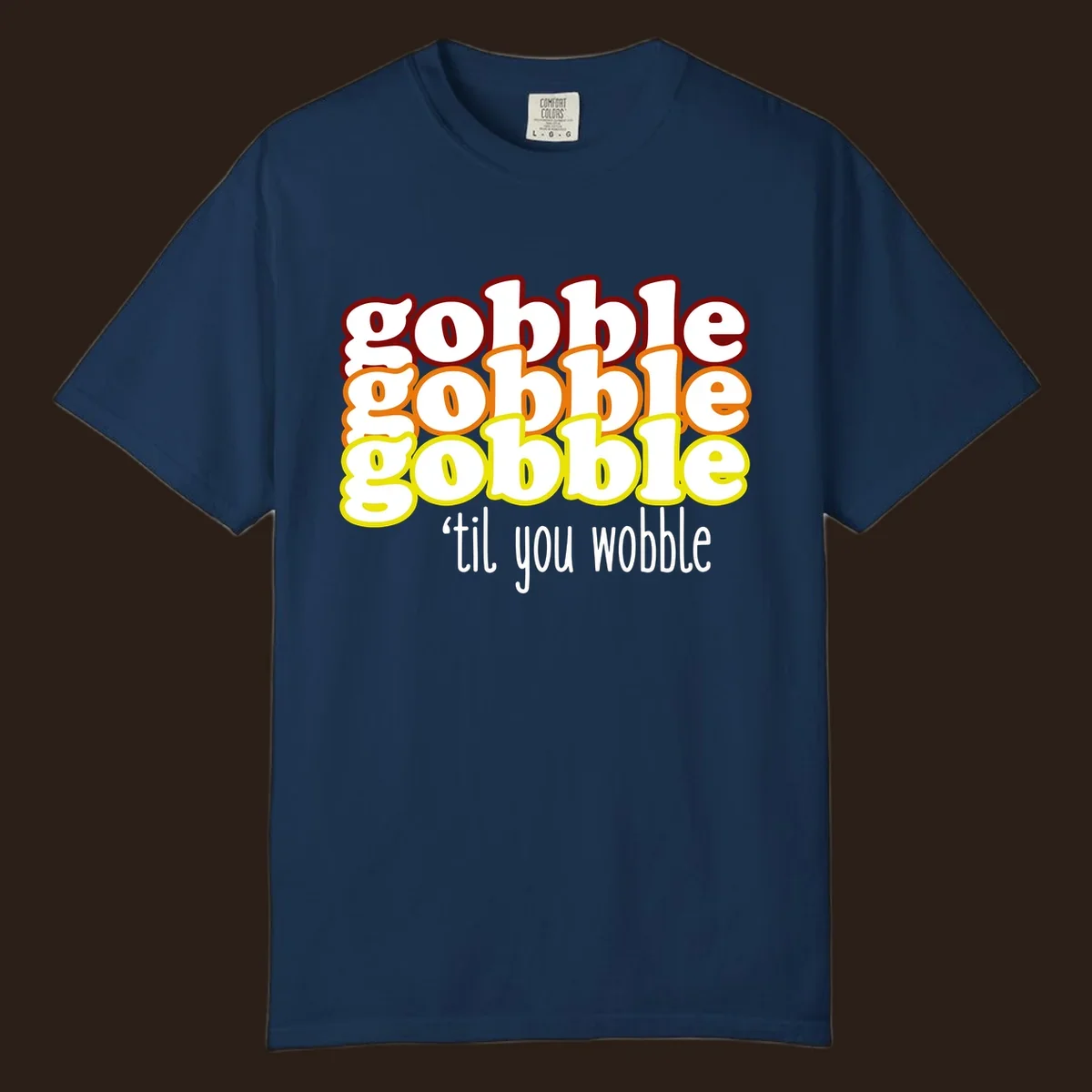 Gobble 'til you wobble thanksgiving text design with stacked gobble words in red, orange, yellow and white text below.