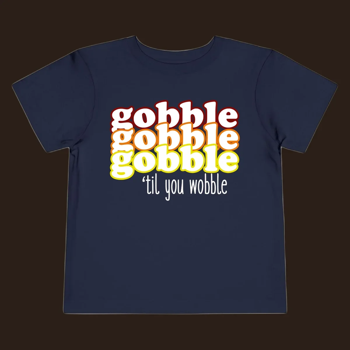 Gobble 'til you wobble thanksgiving text design with stacked gobble words in red, orange, yellow and white text below.