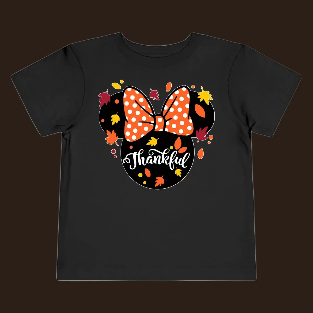Minnie Mouse silhouette with polka dot bow and fall leaves, text reads Thankful.