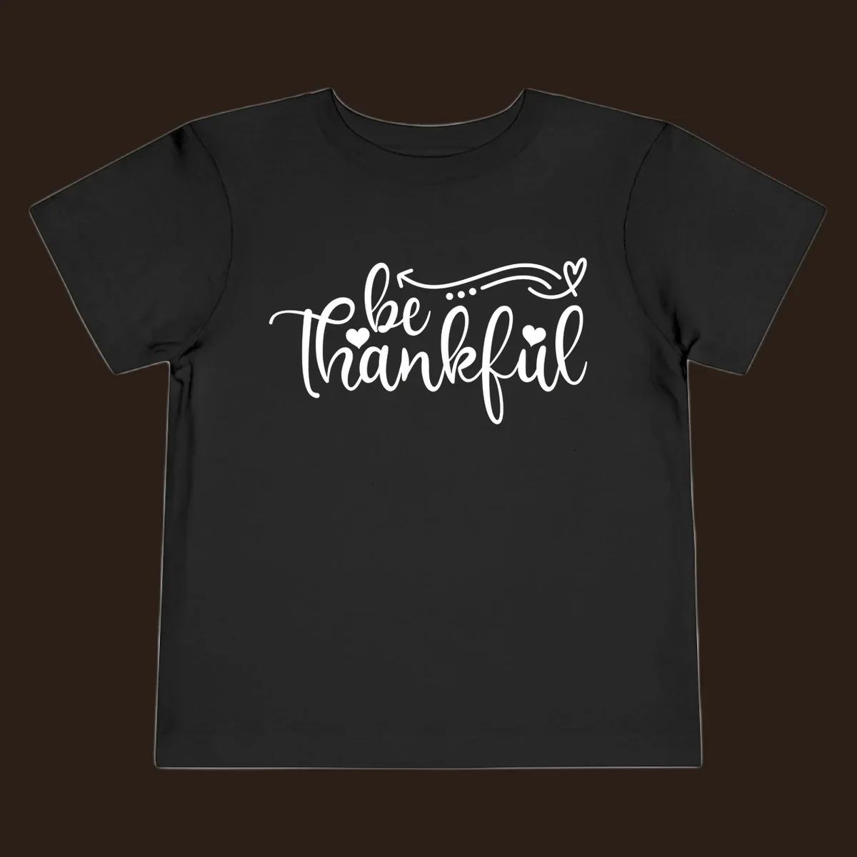 White script text 'be thankful' with hearts and decorative swirls for Thanksgiving.
