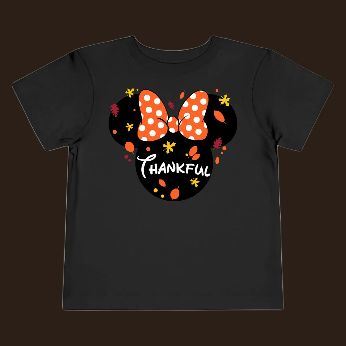 Minnie Mouse silhouette with polka dot bow and 'THANKFUL' text, surrounded by fall leaves.