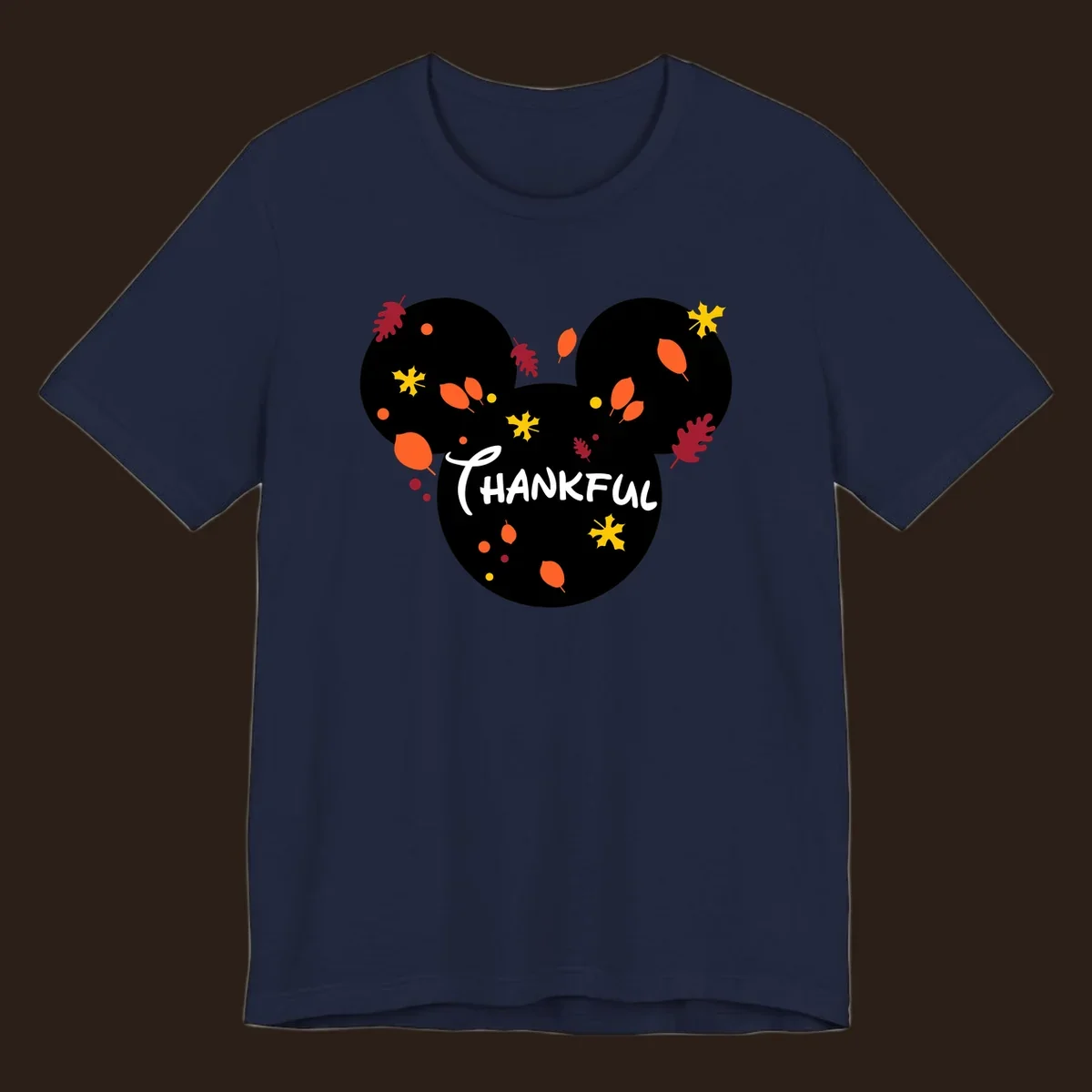 Mickey ears shape with fall leaves and the word THANKFUL in white text.