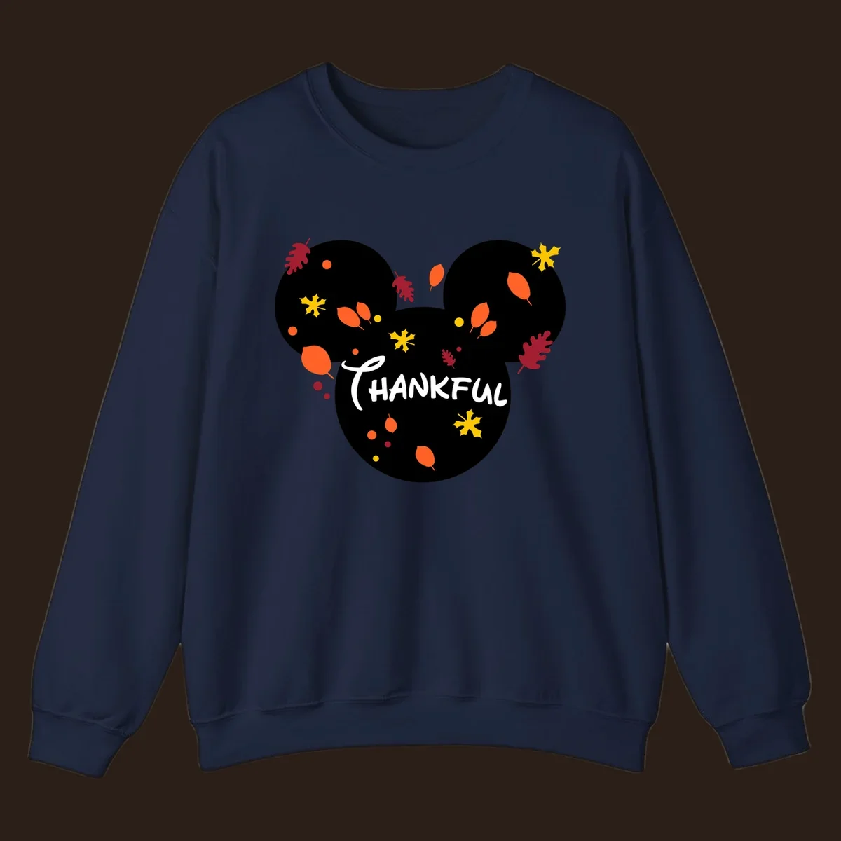 Mickey ears shape with fall leaves and the word THANKFUL in white text.